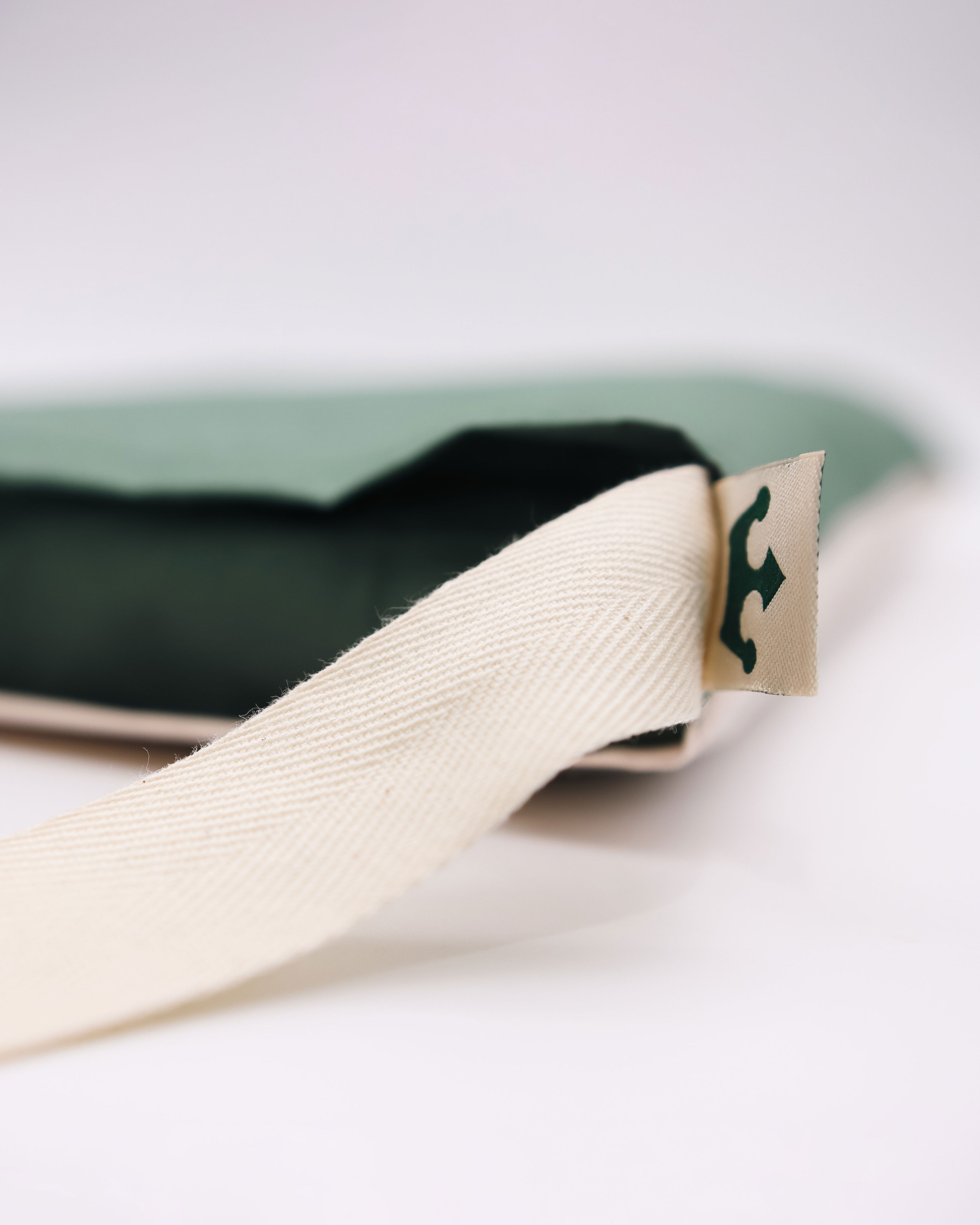 Close-up of a totel bag product with a beige strap and visible brand logo on a white background