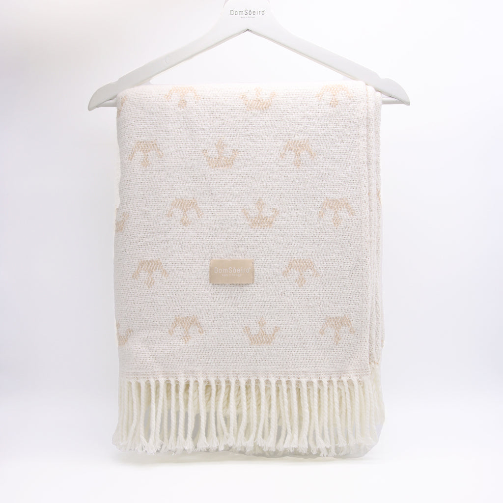 White textured blanket with fringe and subtle pattern on a white background