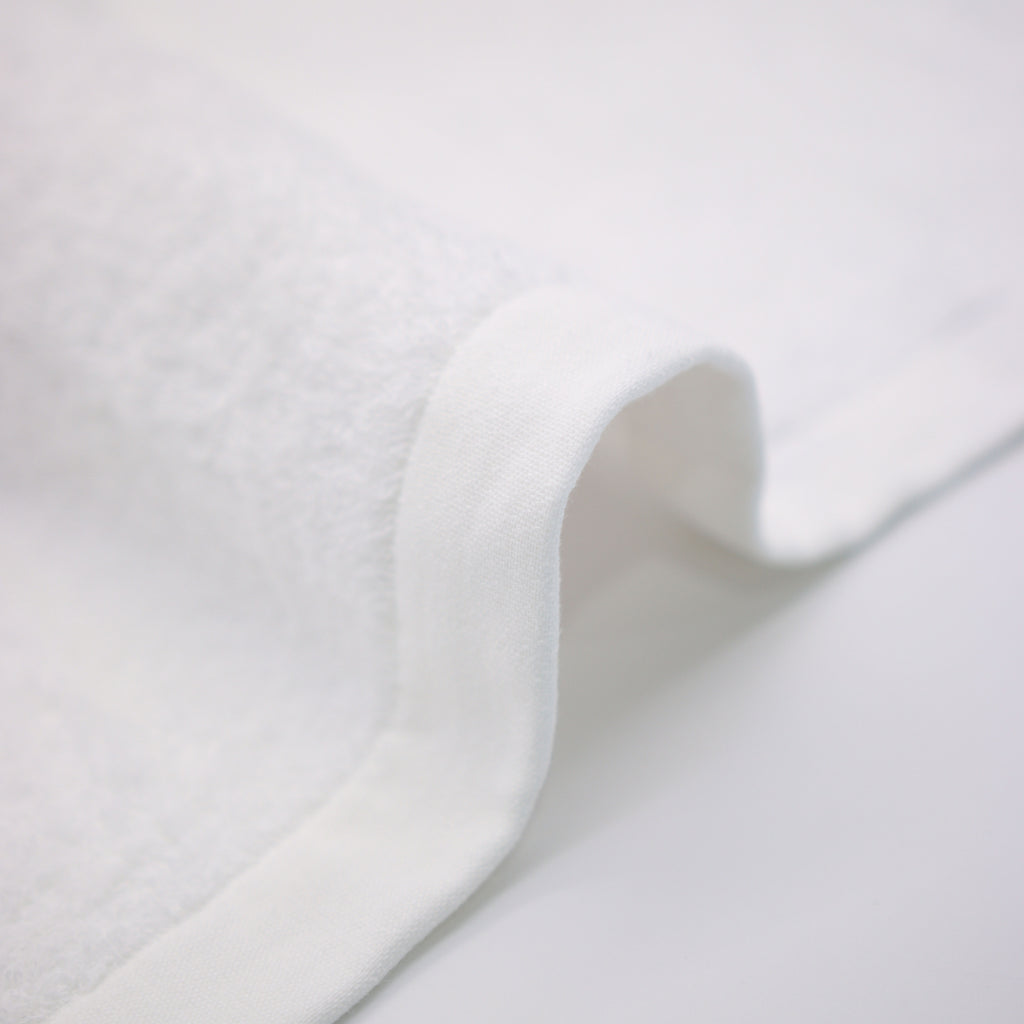 border of white towel on detail on top a white table