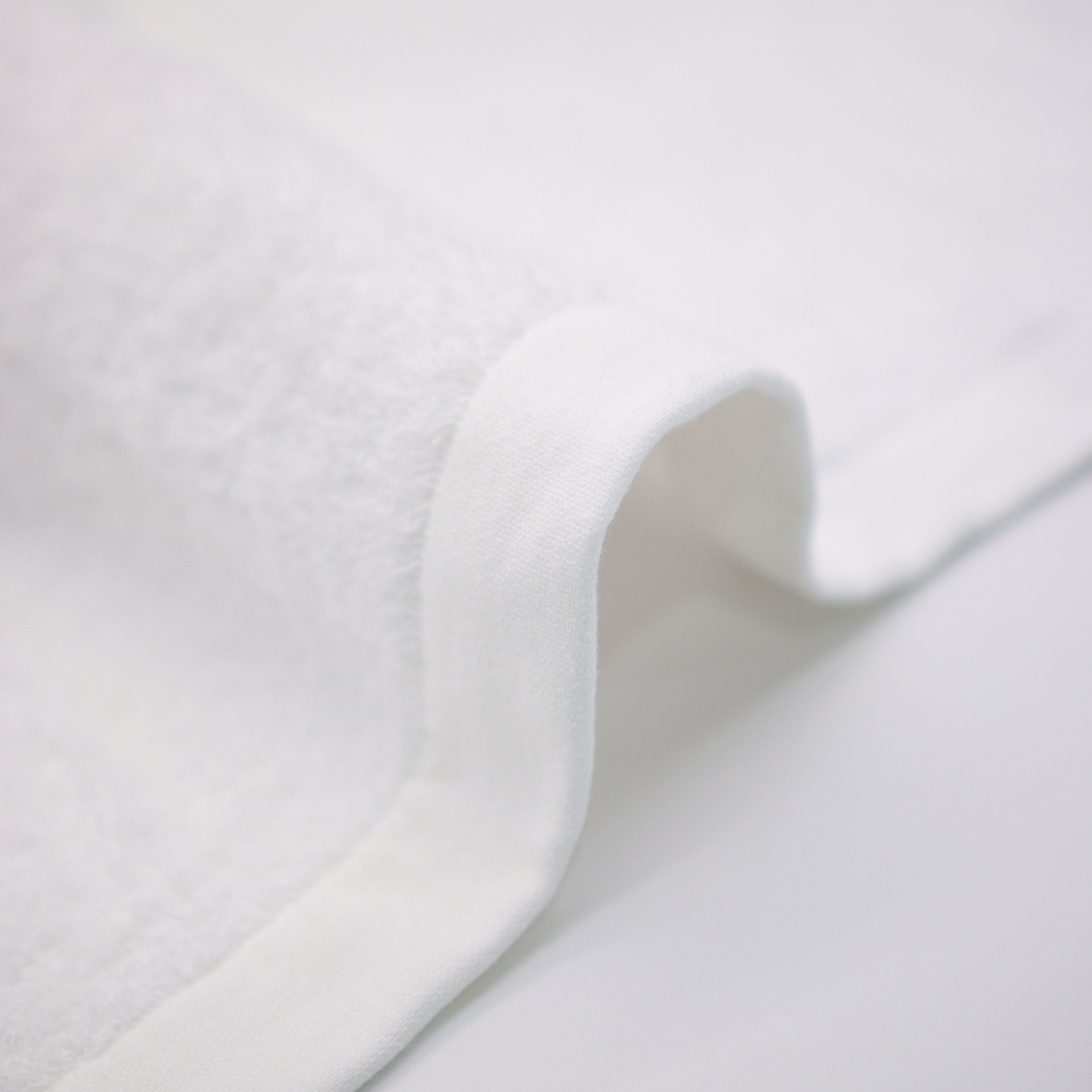 border of white towel on detail on top a white table