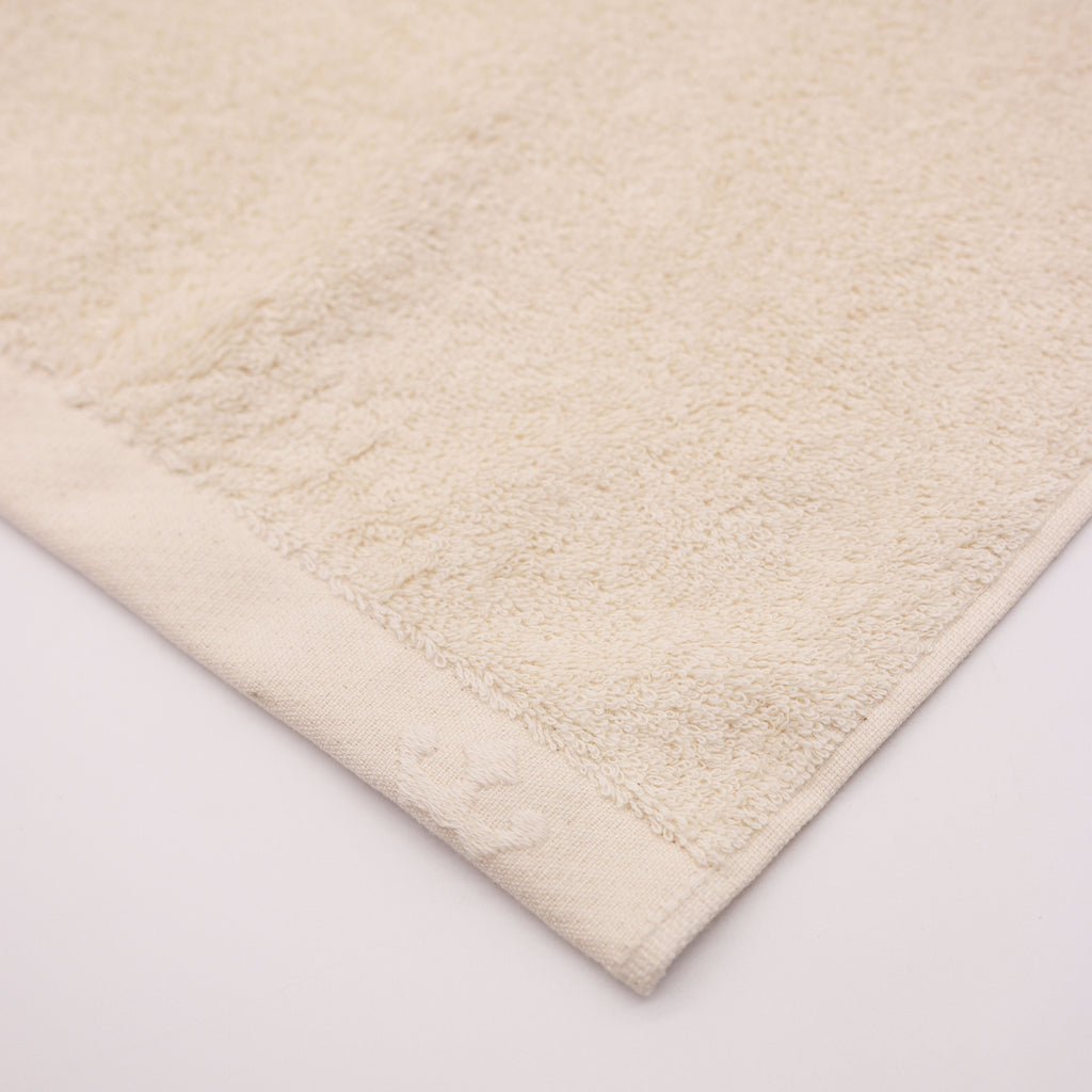 detail of corner bege towel with crown logo
