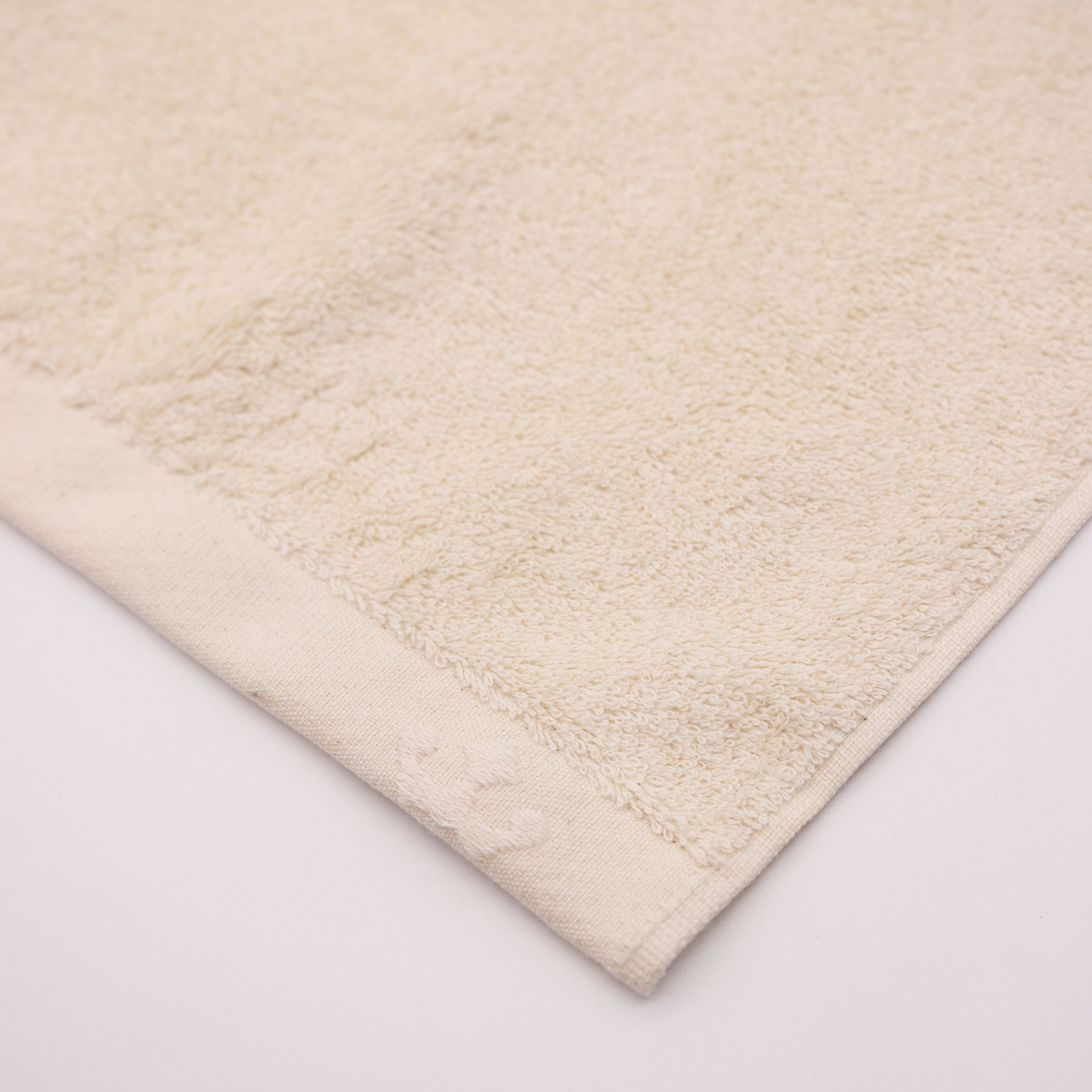 detail of corner bege towel with crown logo