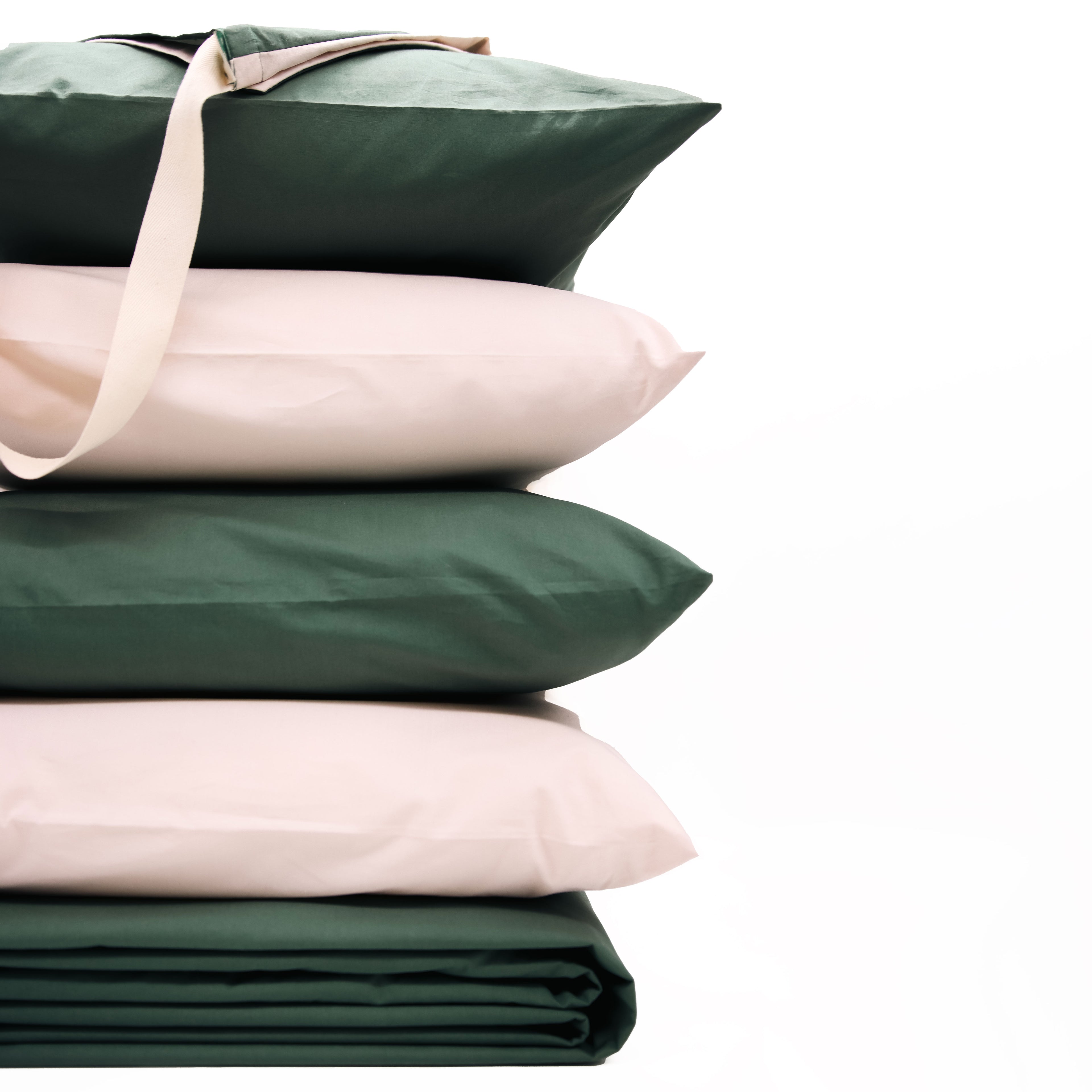 Stack of green and beige pillows on a white background