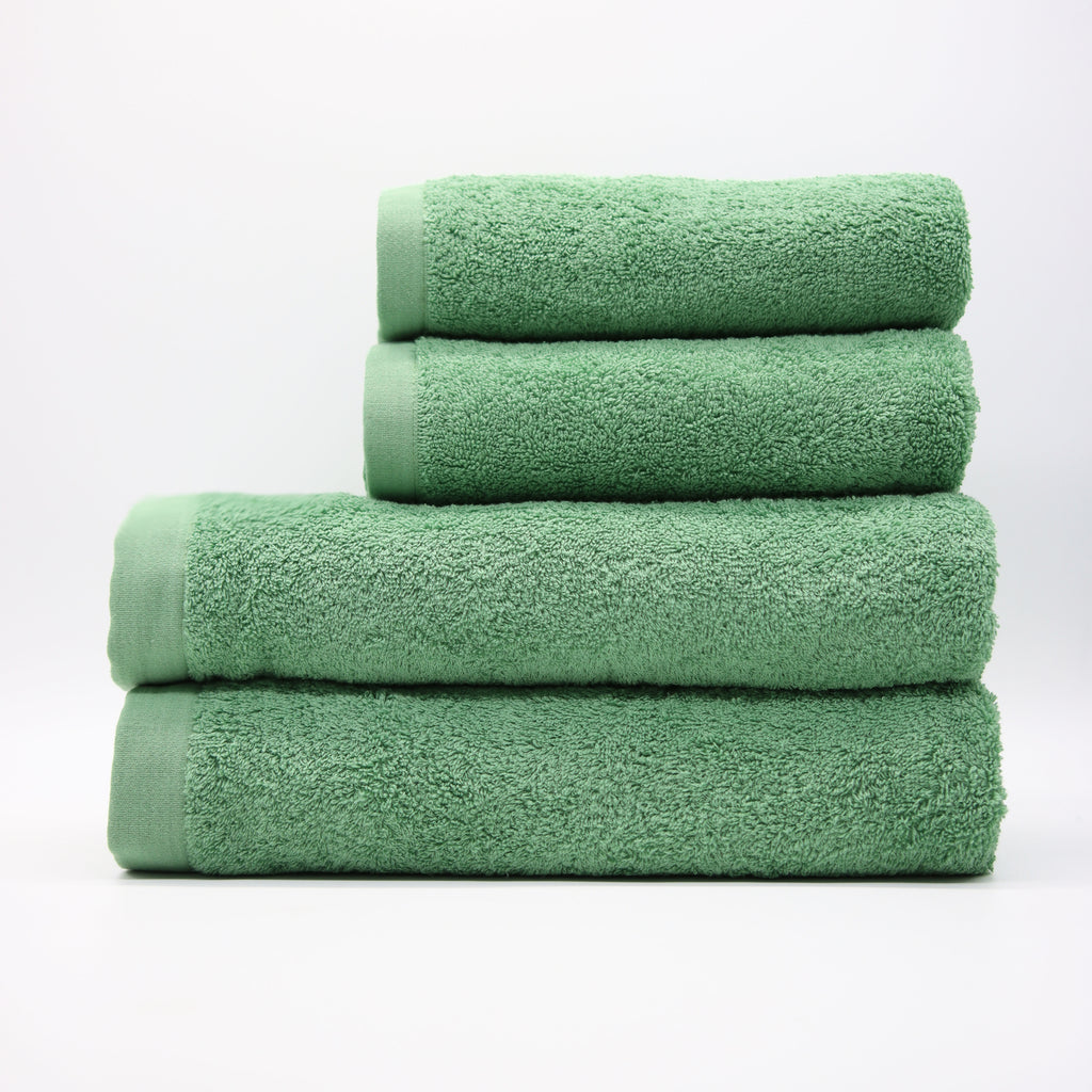 Stack of green towels on a white background