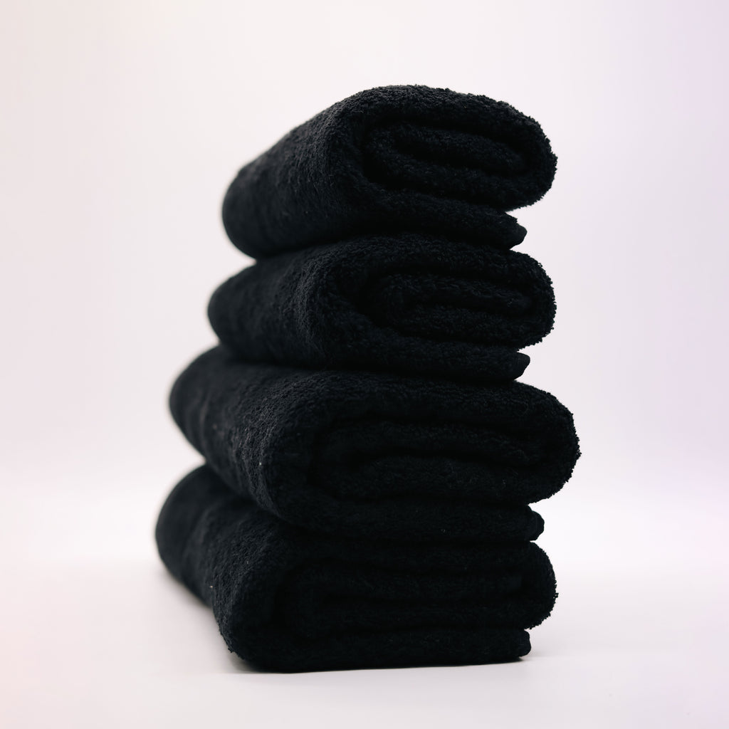 four black towels folded on top of each other