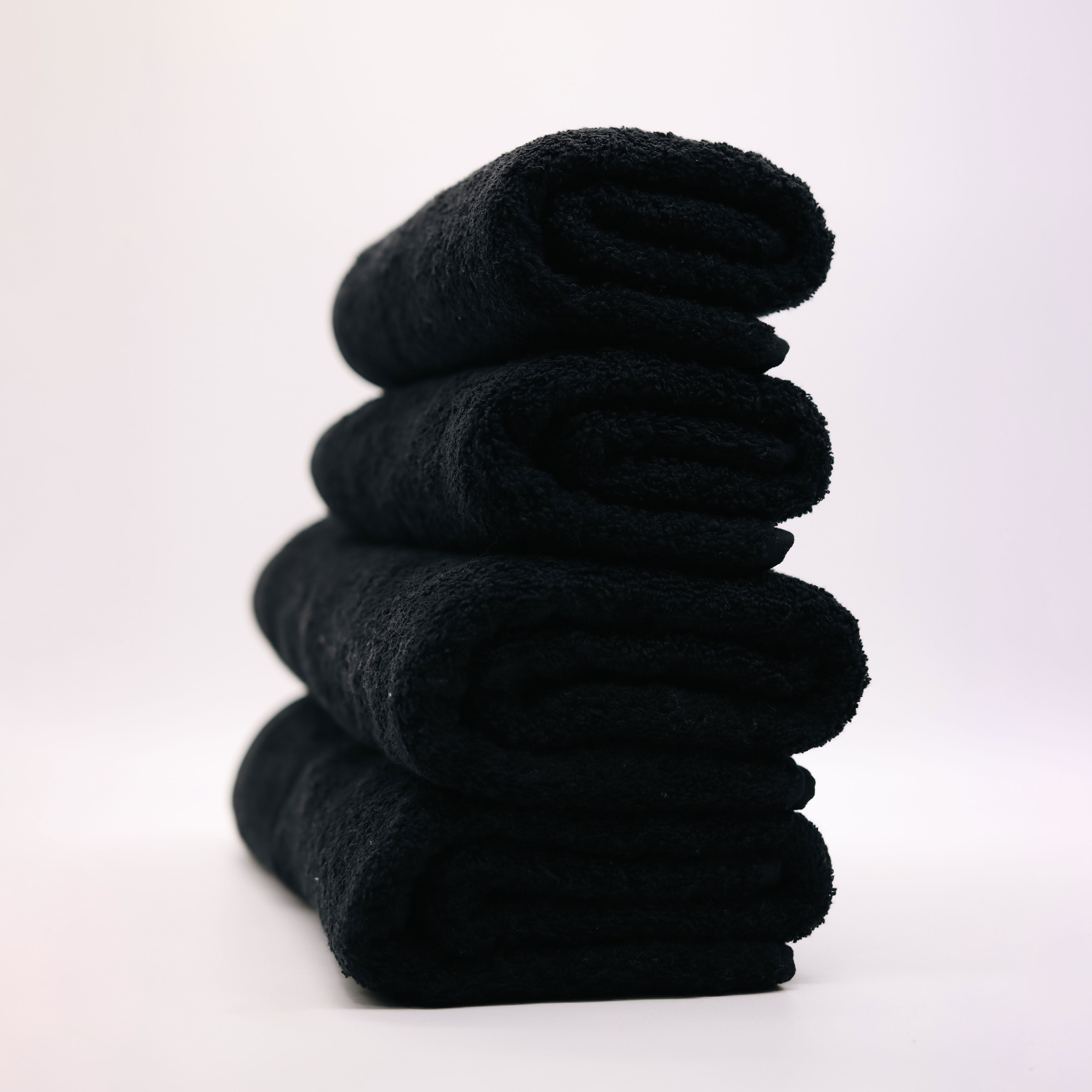 four black towels folded on top of each other