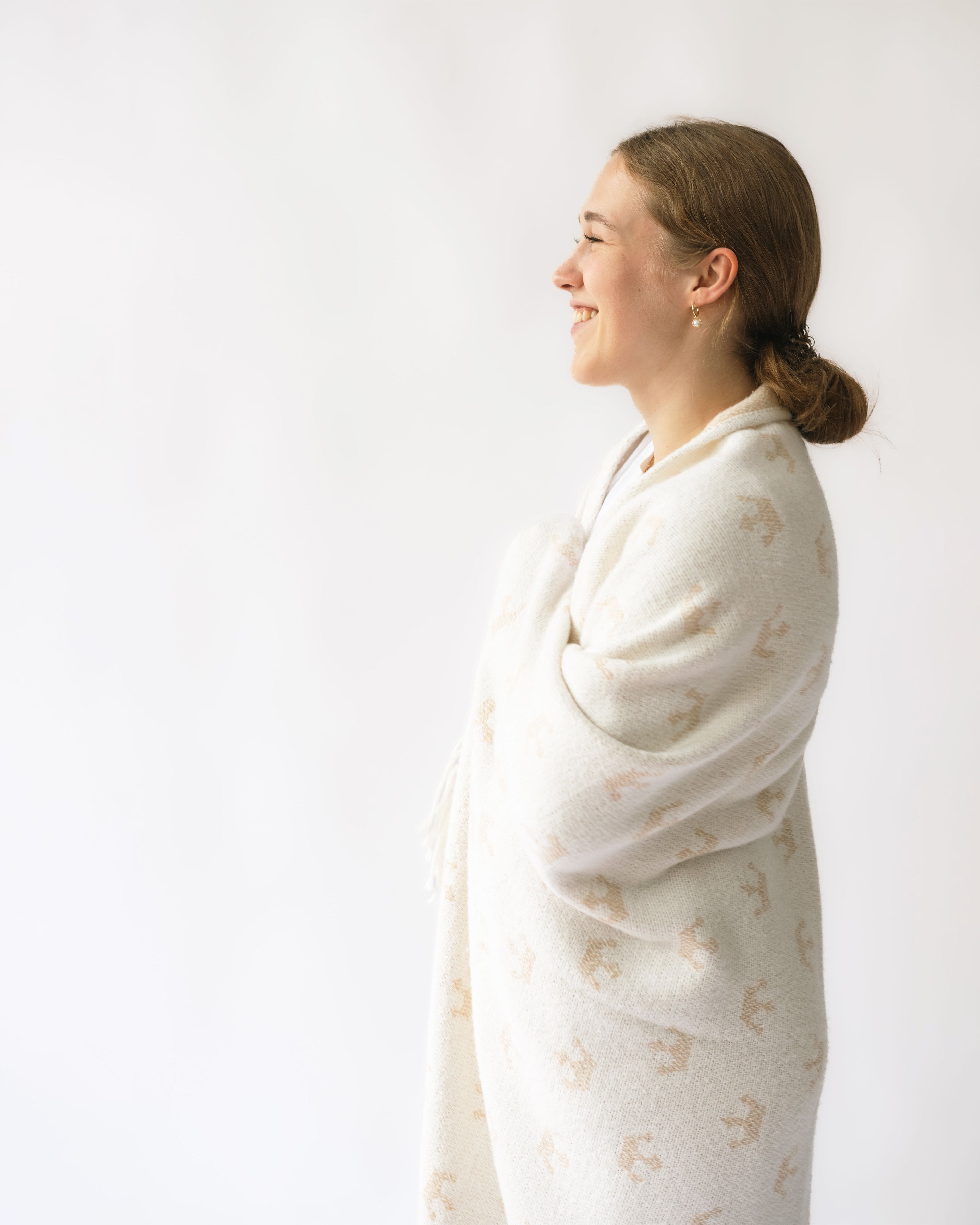 Woman wearing a white patterned dress against a plain background