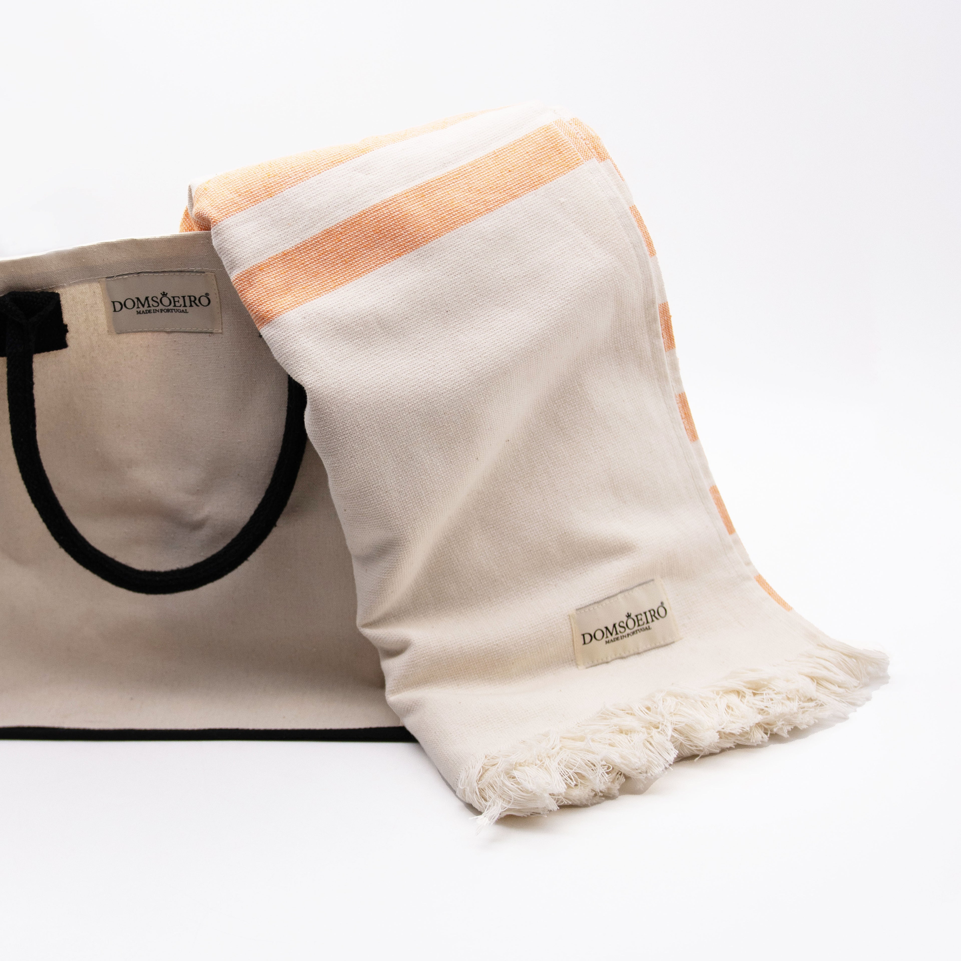 Beige tote bag with a white and peach striped towel on a white background