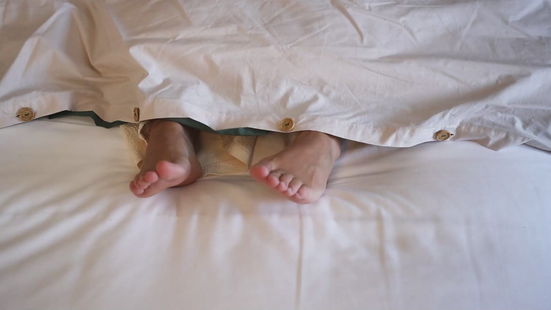 shaking feets under duvet on bed