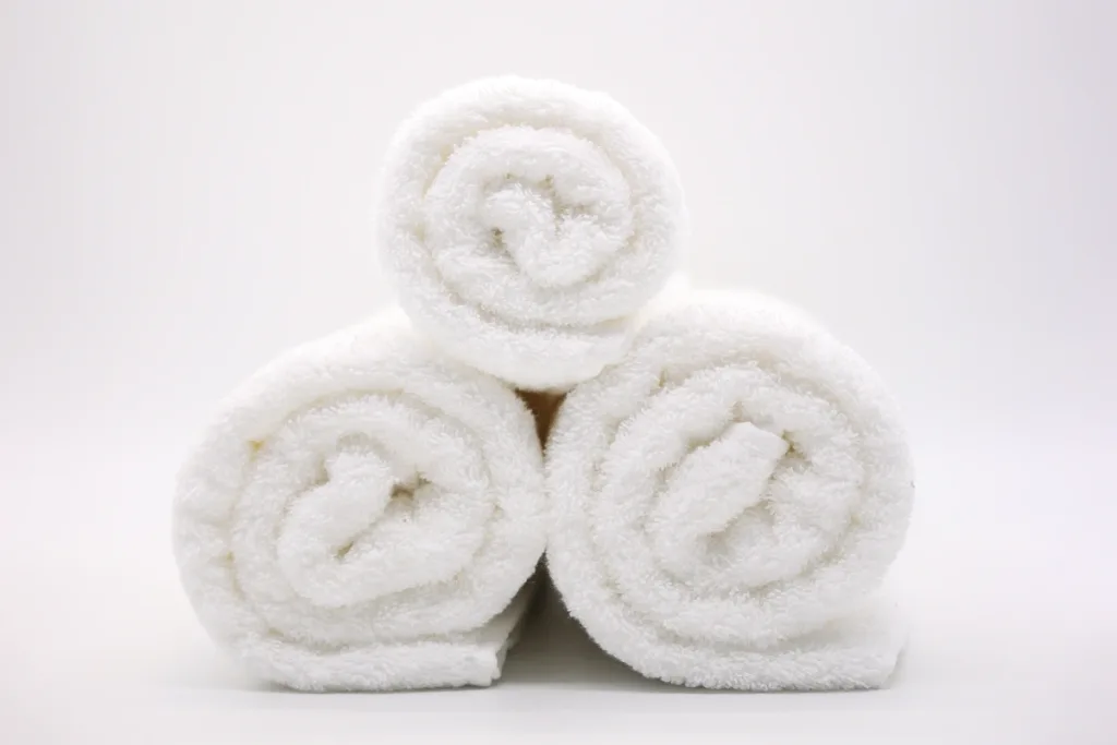 três toalhas brancas enroladas da DomSoeiro