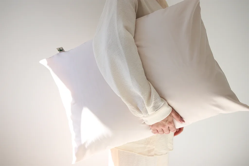 A person holding a beige pillow from DomSoeiro
